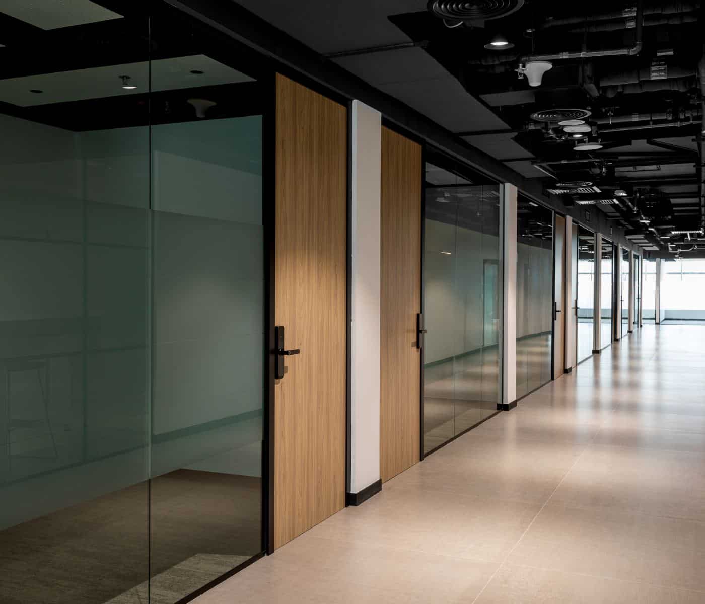 Bright office hallway at Sentinel Dubai co-working space showcasing private glass offices and modern interior design.