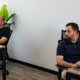How Do You Plan Office Space for a Growing Team_ ‣ Sentinel Dubai Two men sit at separate desks in a bright office, each working on a computer; a plant sits behind the left desk.