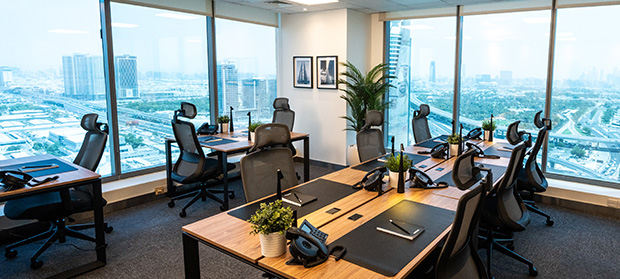 What Does a Serviced Office Agreement Include_ ‣ Sentinel Dubai Furnished serviced office with desks, ergonomic chairs and floor-to-ceiling windows overlooking Dubai’s skyline.